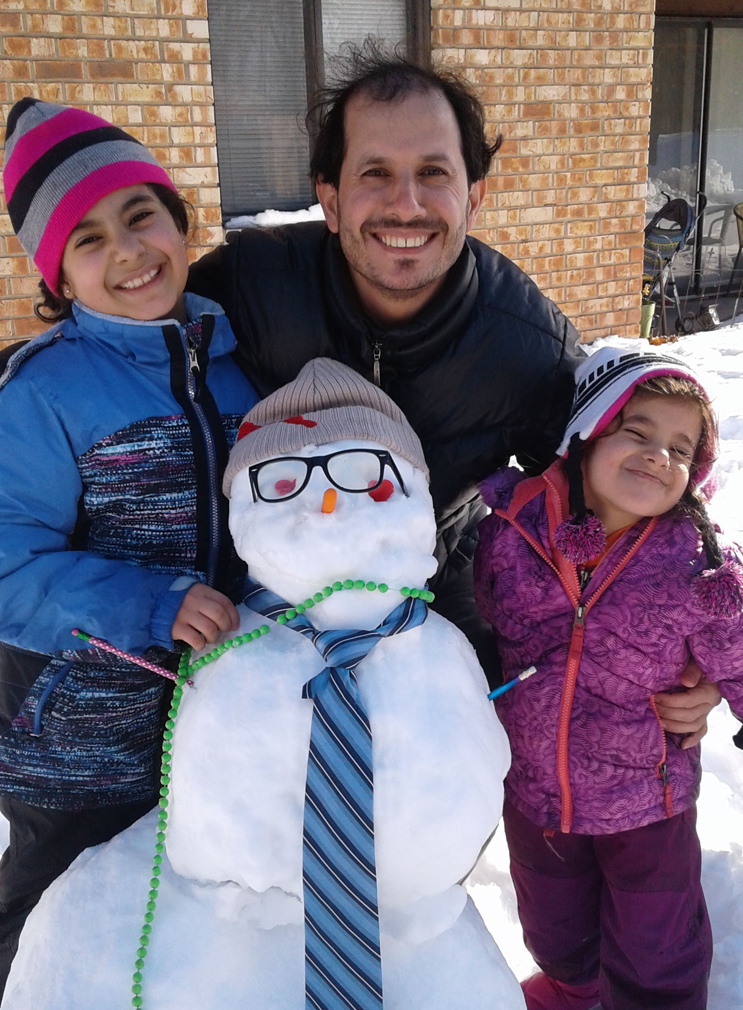 PMR resident with his two daughters building a snowman. 