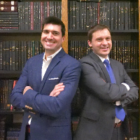 Drs. Christopher J. Tignanelli and Schelomo Marmor pose for a photo in front of a bookcase.