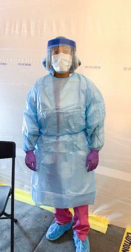Dr. Dwivedi standing in scrubs and with a face shield.