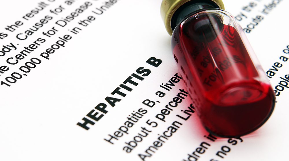 A blood sample sitting on top of a piece of paper with information about Hepatitis B