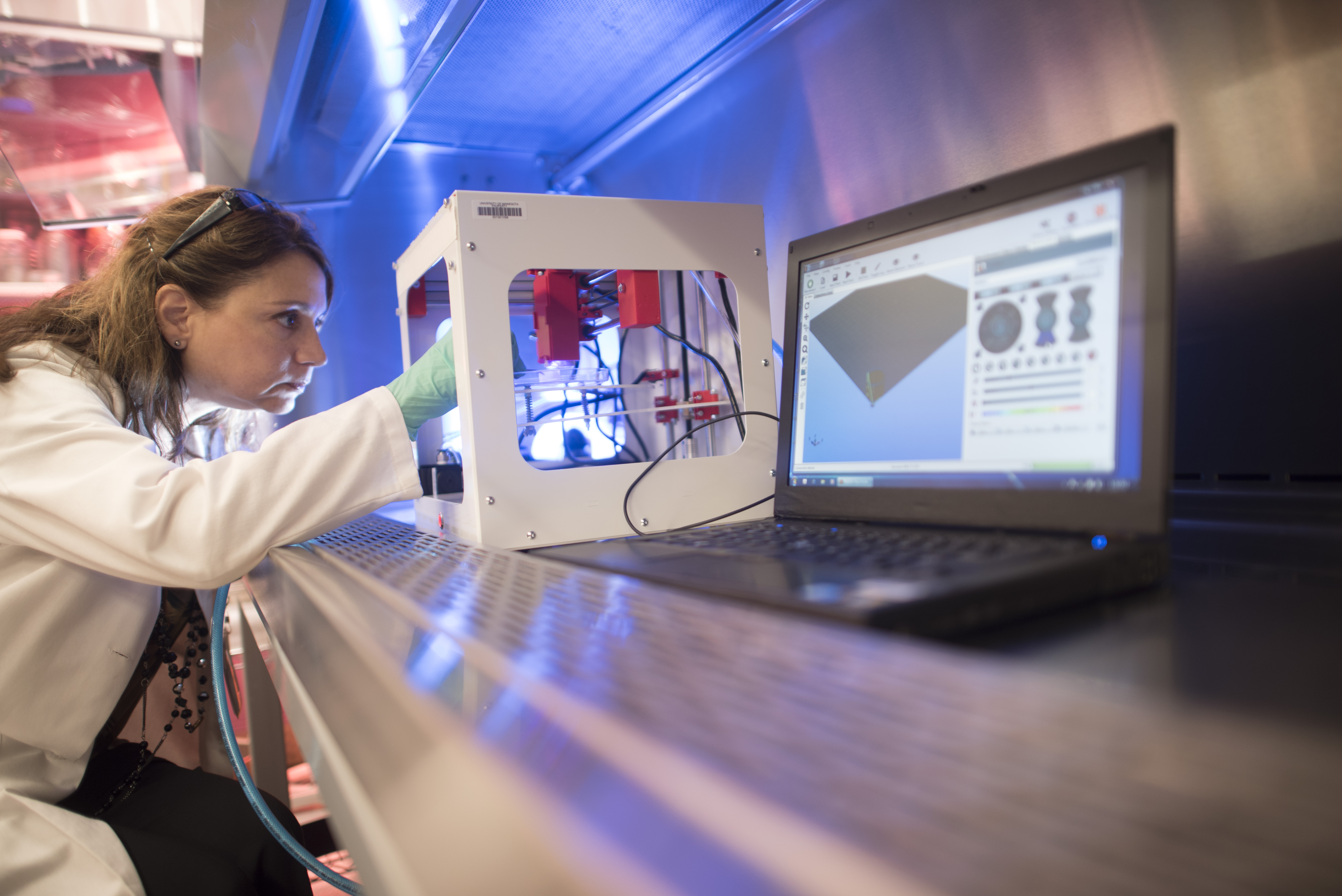 Researcher in a white coat at a 3D printer