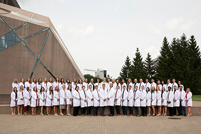 Physical therapy students standing and wearing their white coats