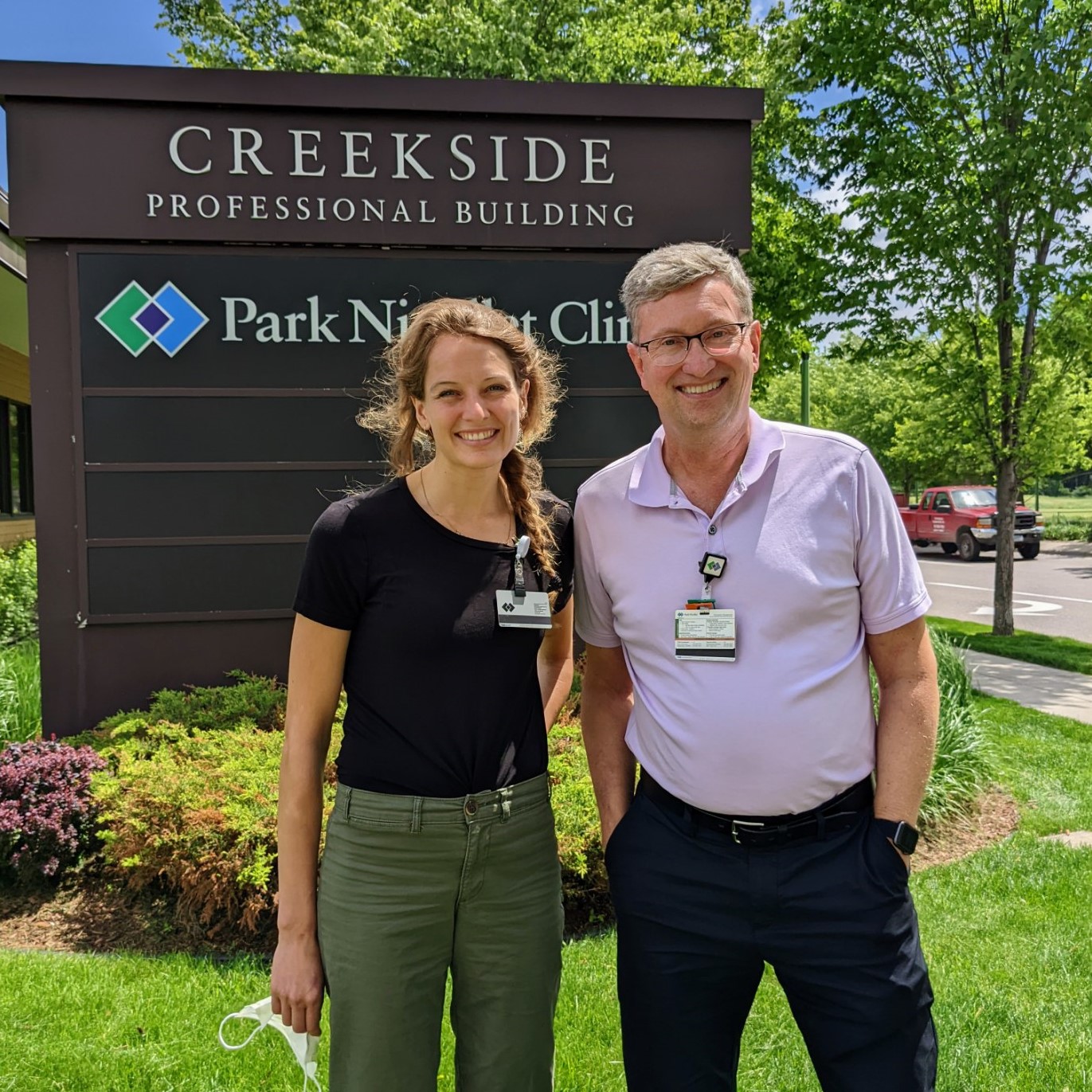 Student and preceptor in front of Creekside sign