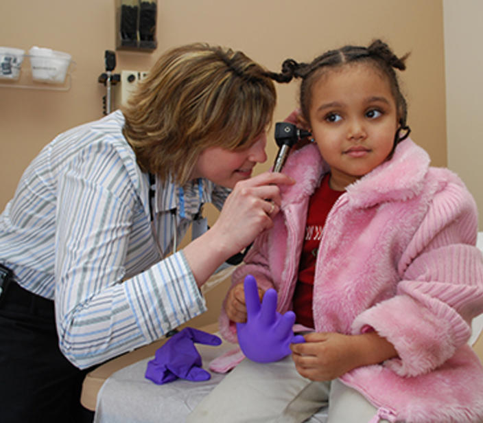 Provider checking patient's ear.