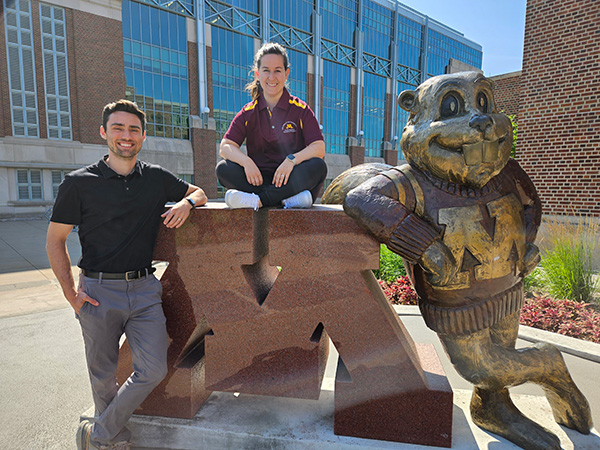 Sports medicine fellows next to Goldy Gopher on campus