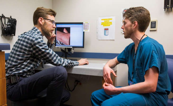 Preceptor and alumnus Thomas Heinitz, M.D., discusses a patient’s care plan with first-year resident Jesse Susa, M.D., at the Duluth Family Medicine Clinic.