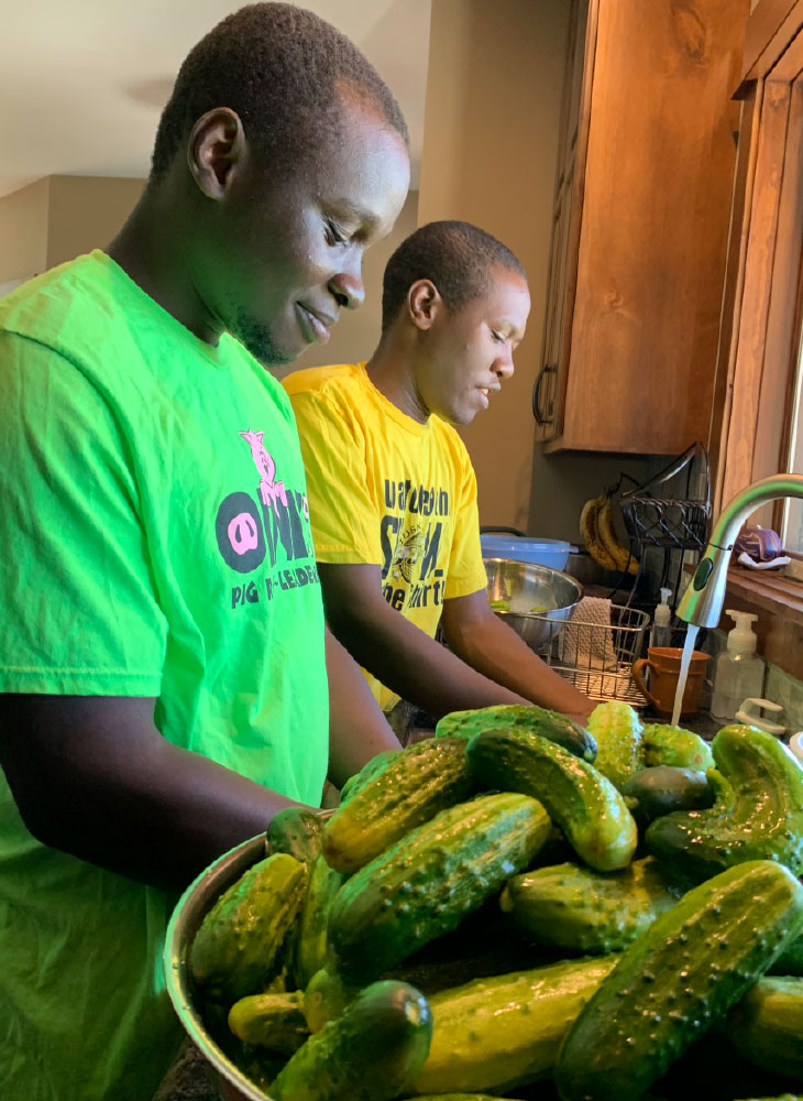 Photo of two people cleaning cucumbers