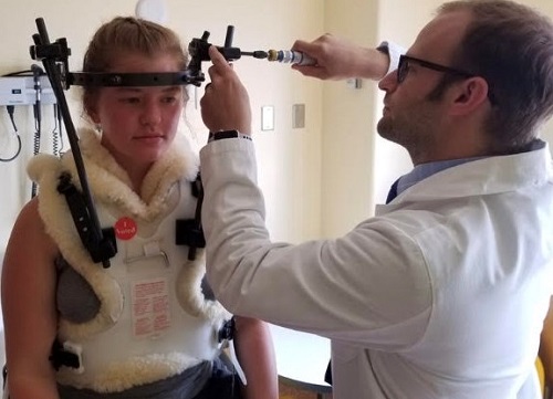 Sami Kaiser with Dr. David Freeman adjusting her halo vest