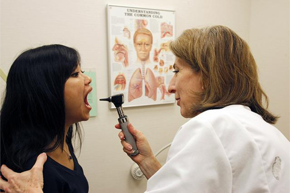 Doctor performs throat exam