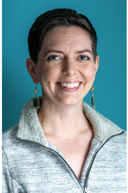 Dr. Kristina Krohn, a smiling white woman in a pale grey zippered top