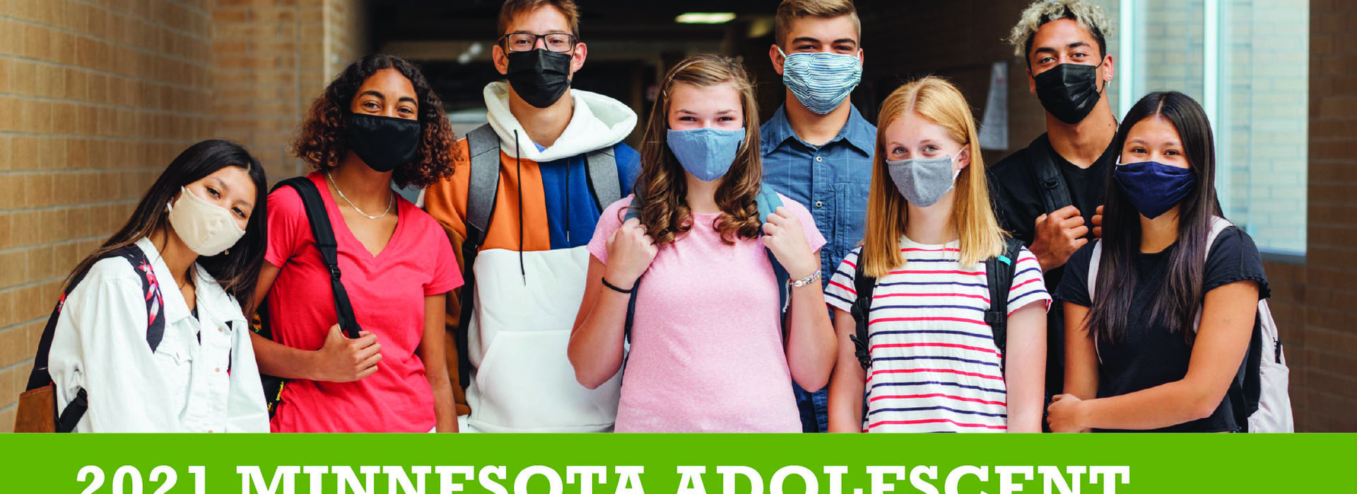 Teenager standing in a school hallway wearing masks