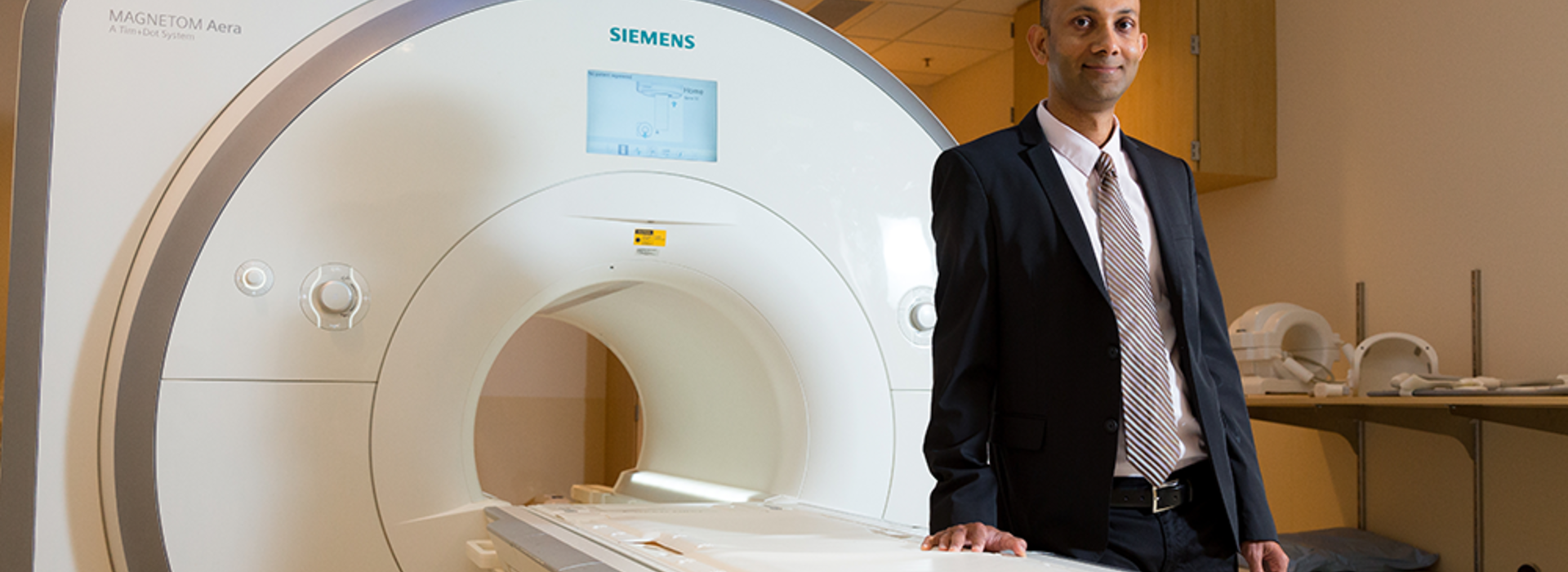 Dr. Chetan Shenoy standing in front of an MRI machine.
