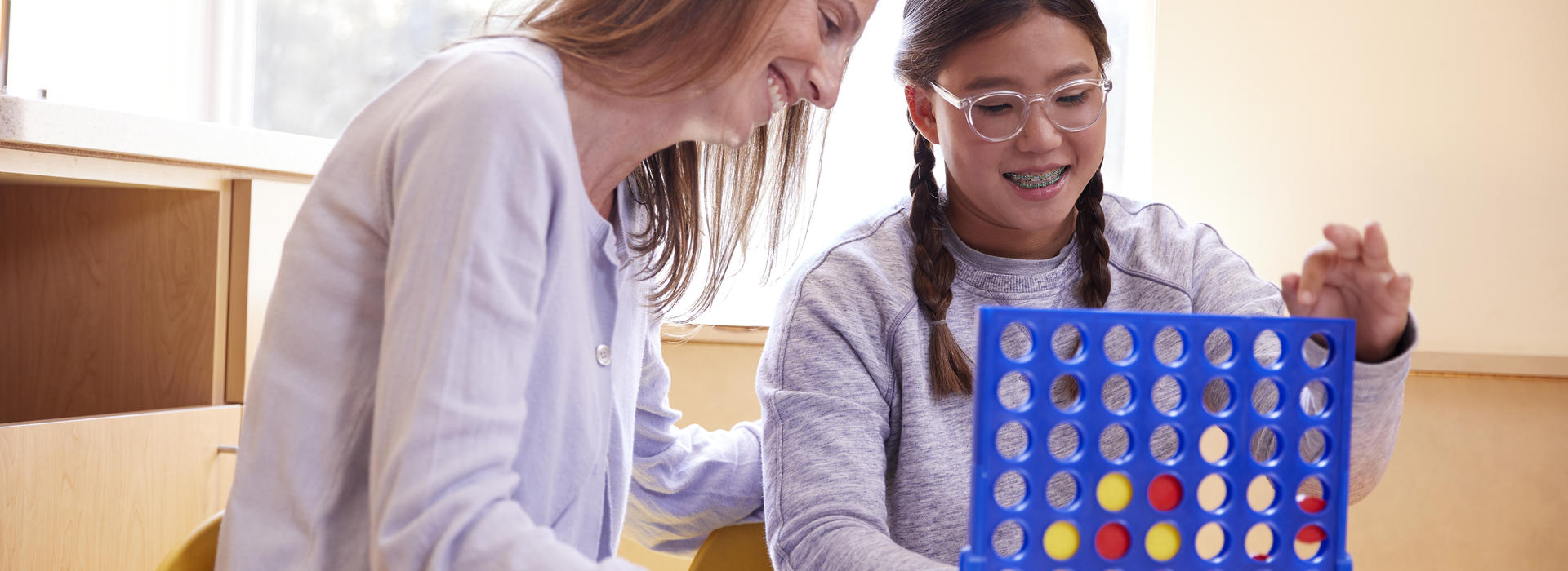Occupational Therapist and Child Playing Connect 4