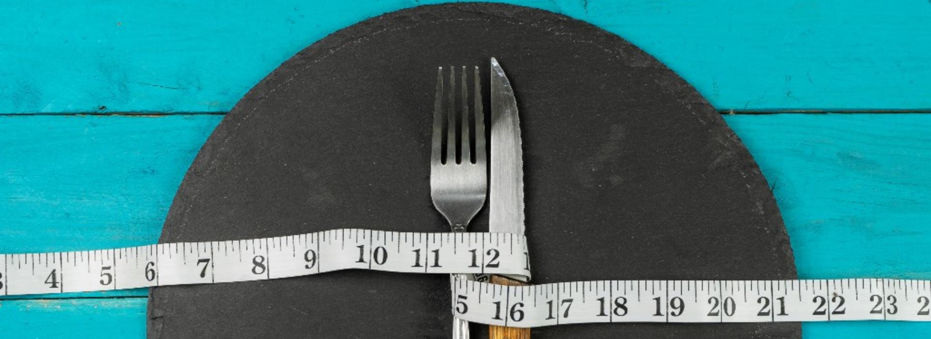Concept of diet and weight with cutlery