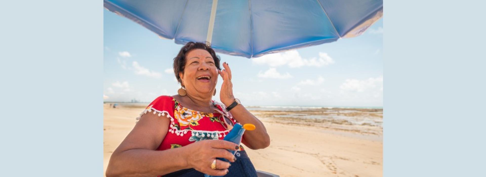 Senior woman using a suntan lotion on the beach