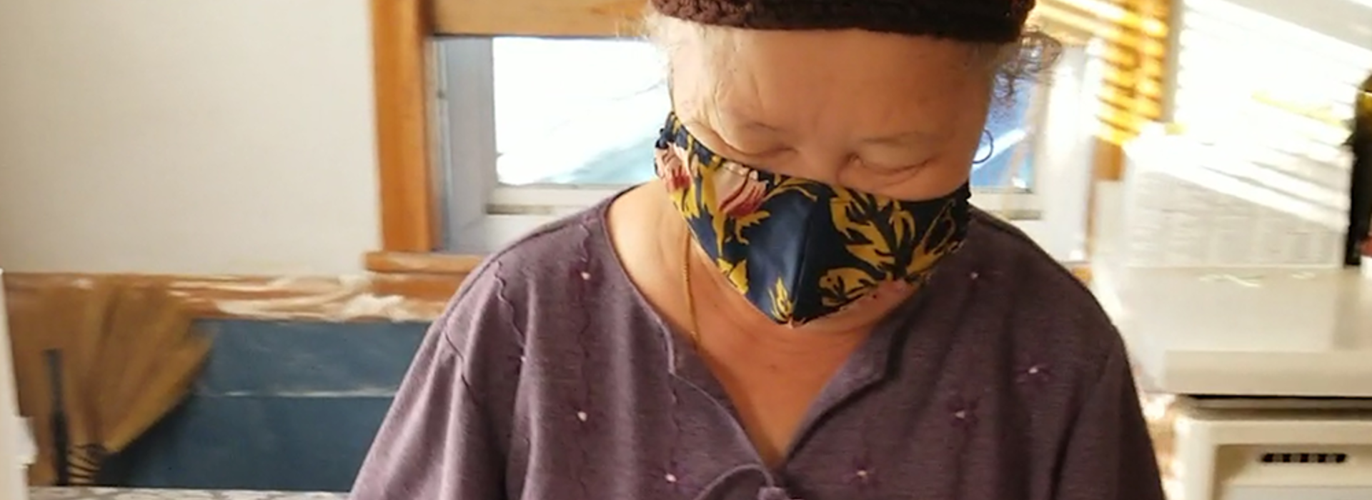 An older woman wearing a mask.