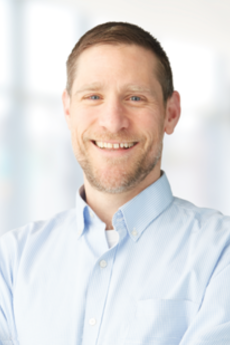 Dr. Brett Hendel Paterson, a smiling white man in a button down shirt