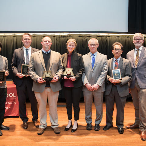 A group of people standing with their awards.