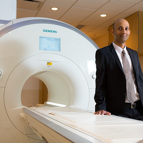 Dr. Chetan Shenoy standing in front of an MRI machine.