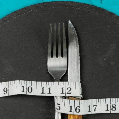 Concept of diet and weight with cutlery