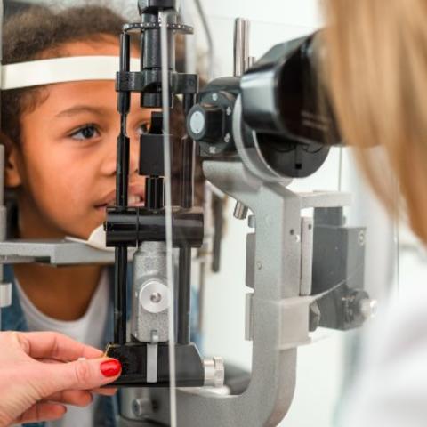 Young girl sitting at ophthalmologist office or an eye exam. Credit: Getty Images.