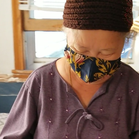 An older woman wearing a mask.