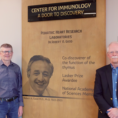 Tucker LeBien and Marc Jenkins standing in front of Robert Good's Lab Door in UMN Center For Immunology