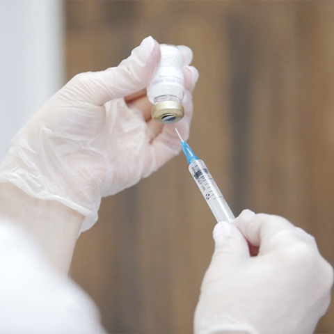A doctor holding a vaccine and needle.