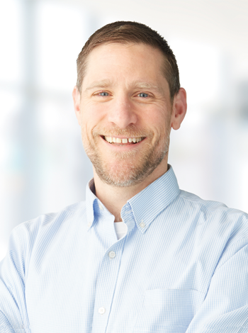 Dr. Brett Hendel Paterson, a smiling white man in a button down shirt